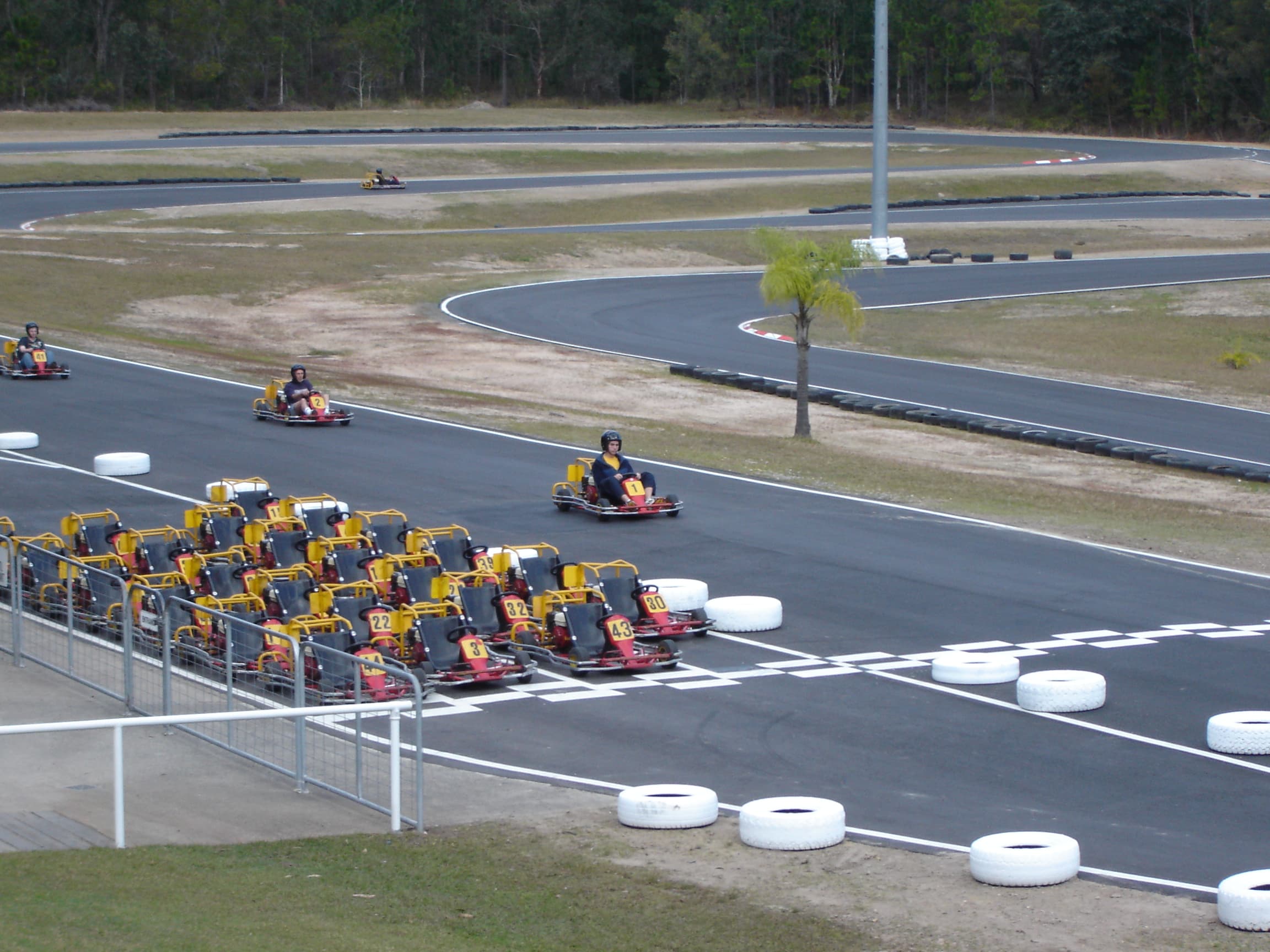 Go-karts racing wheel-to-wheel on a karting circuit — the type of action at Luddenham Raceway near Western Sydney Airport